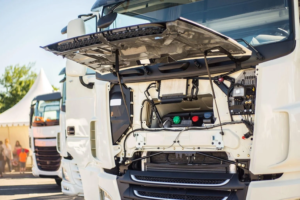 Caminhão com capô levantado expõe motor e sistema de arrefecimento, destacando potencial de inspeção e manutenção de mangueiras de silicone Flexfab em componentes como o intercooler.